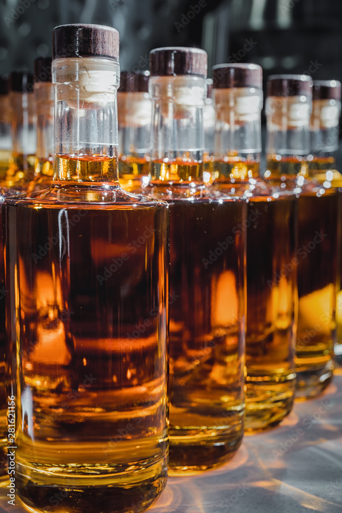 Small liquor production based on maple syrup. Multitude of pure alcohol bottles not labeled