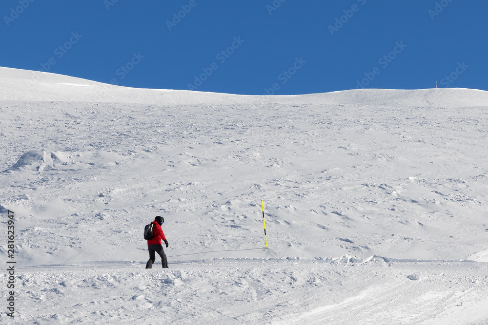 Snowboarder downhill on snowy slope Snowboarder downhill on snowy slope