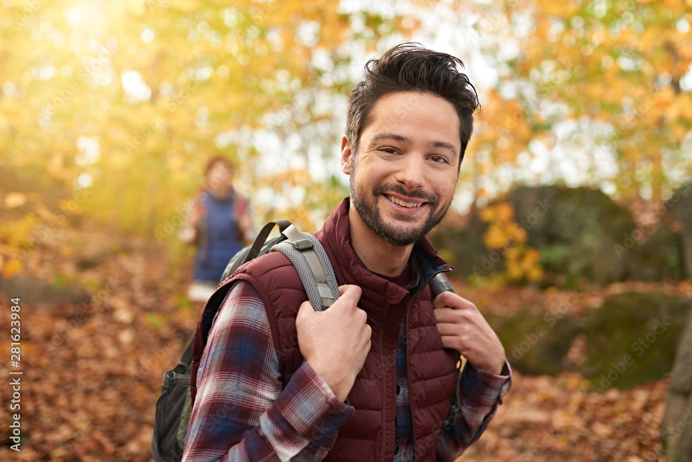 Attractive caucasian couple hiking through the forest in the fall in Canada Attractive caucasian couple hiking through the forest in the fall in Canada
