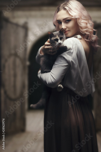 Wallpaper Mural portrait of a beautiful blonde girl with cat on black studio background, young woman with pet, peasant woman against the background of a wooden castle gate Torontodigital.ca
