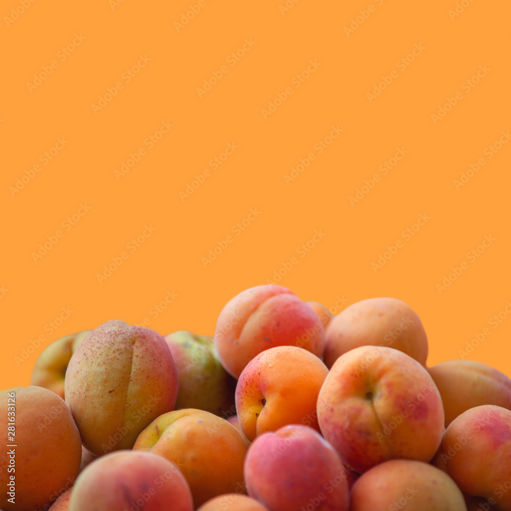 Fresh ripe apricots on an orange background