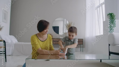 Happy and laughing mom and son play together with a Lizun, a liquid stretchable toy photo