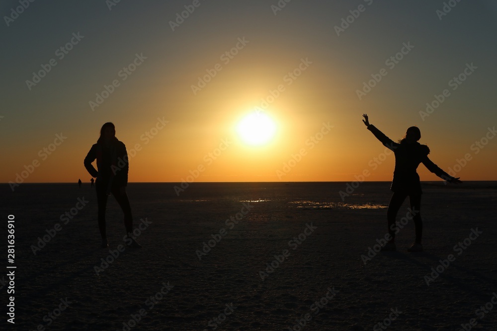 silhouette of man and woman on the beach at sunset