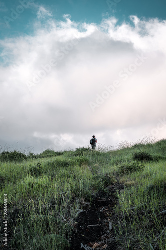 Guy walking among the clouds, mountain hiking