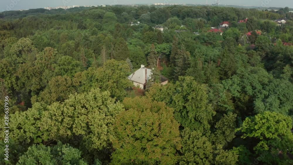 Aerial view abandoned old brick house in the forest at sunset. Old small house surrounded by forest top view. Shot Drone 4K.