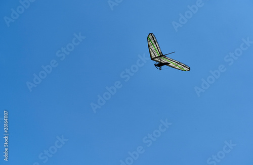A single hang glider among the clouds high up in the sky. Side view.