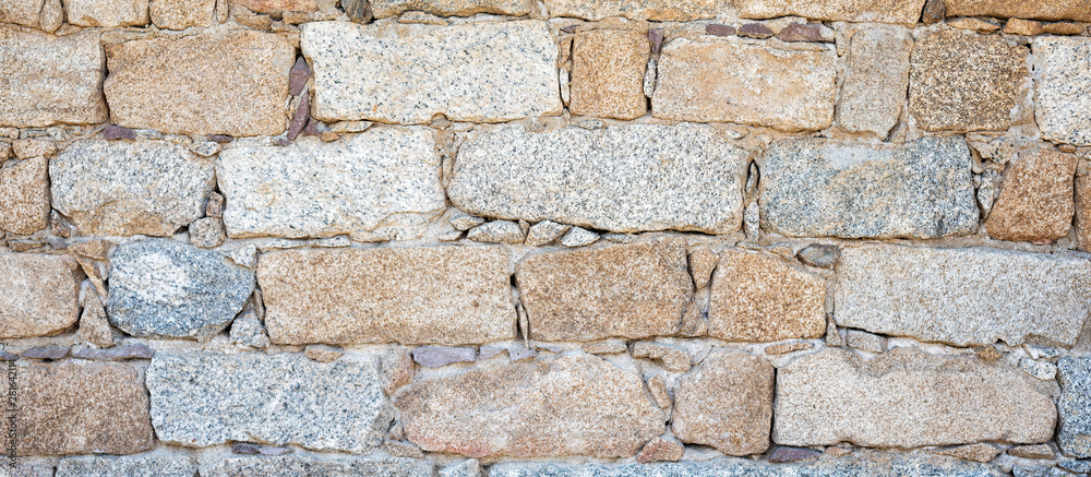 Detail of an old stone wall arranged in an irregular manner. Architecture constructions. Vintage background. Detail of an old stone wall arranged in an irregular manner. Architecture constructions. Vintage background.