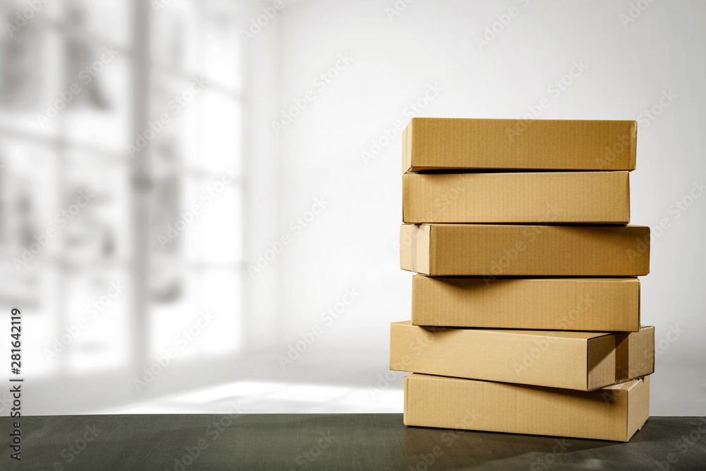 Boxes in a pile on a table top on a white wall background. Some parcel to send. Boxes in a pile on a table top on a white wall background. Some parcel to send.