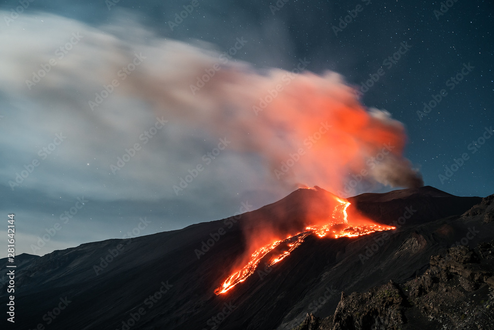 Eruption Volcano Etna with smoke and lava flow at night