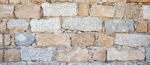 Detail of an old stone wall arranged in an irregular manner. Architecture constructions. Vintage background.