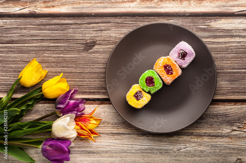 Assortment turkish delight in dark trandy plate on wooden background. photo