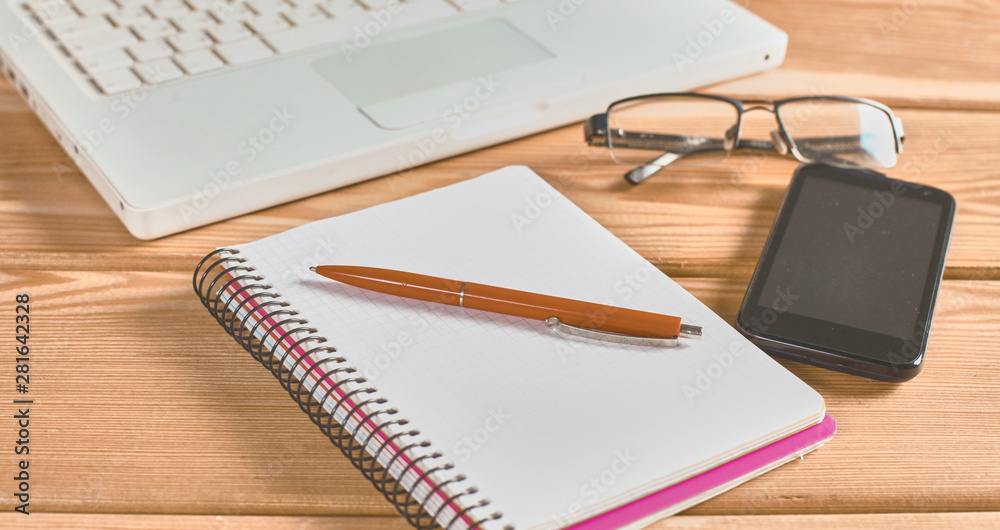 surface of a wooden table with notebook, smartphone, eye glasse surface of a wooden table with notebook, smartphone, eye glasse