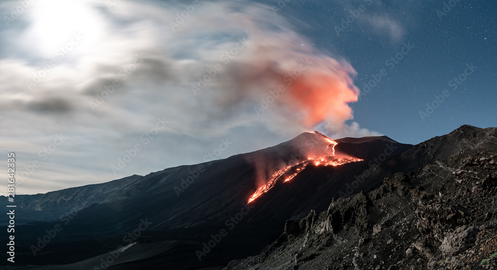 Panoramic photo of the Volcano Etna at night, eruption and smoke