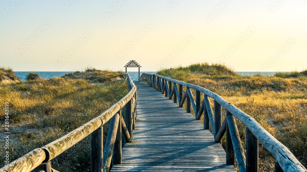 Wooden path to the beach at sunset