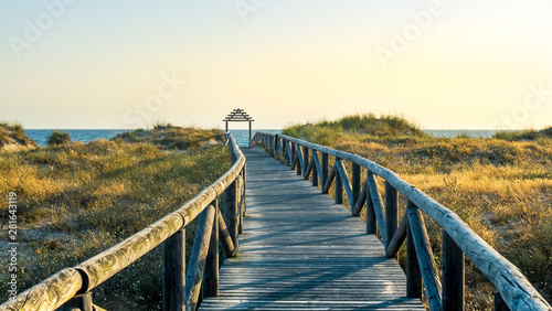 Wooden path to the beach at sunset