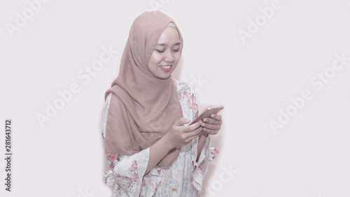 Portait of asian muslim woman wearing head scarf or hijab using smartphone