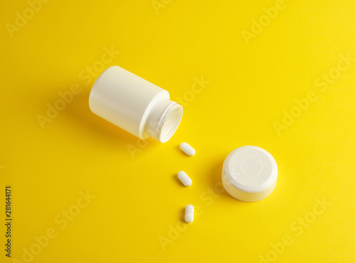 open white plastic jar for medicines and oval pills