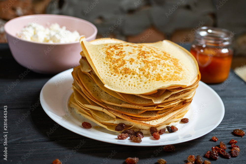 Crepes on a wooden table with honey and raisins. Crepes on a wooden table with honey and raisins.