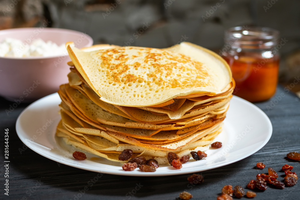 Crepes on a wooden table with honey and raisins. Crepes on a wooden table with honey and raisins.
