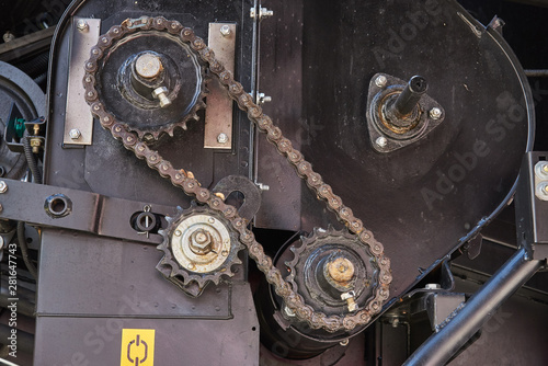 Chain gear with chain tensioning mechanism. Heavy grease chain. Fragment of a combine harvester