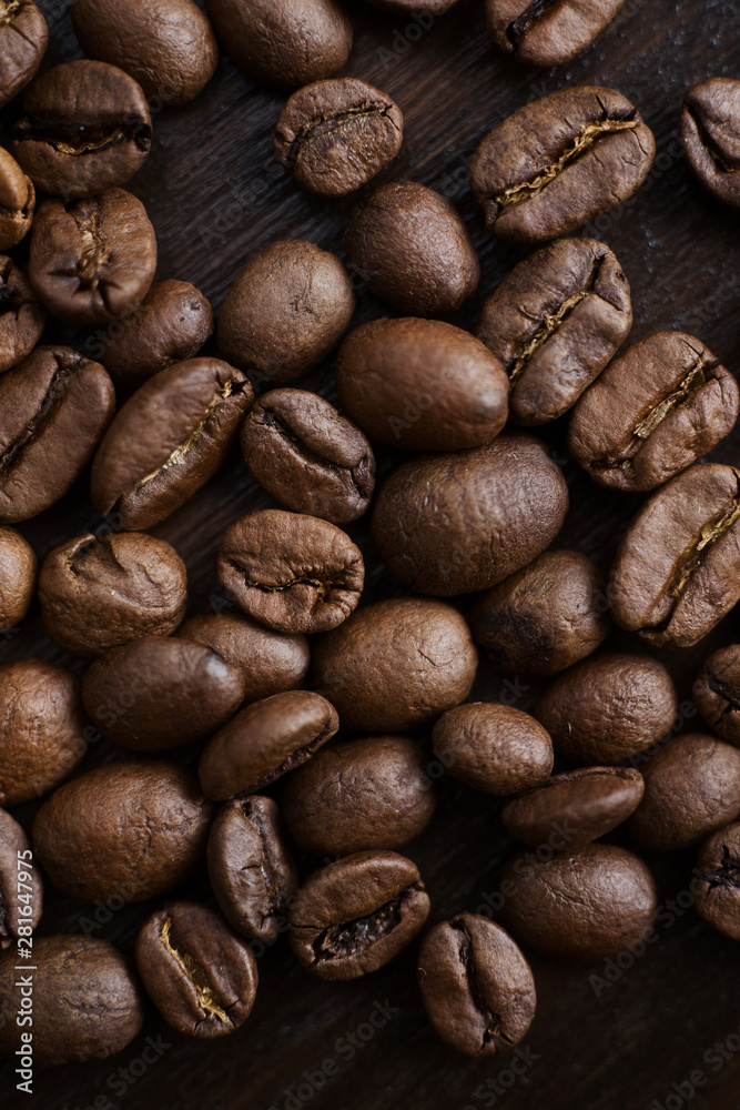 Naklejka premium Close-up coffee beans on a dark wood background