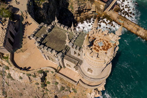 Yalta, Crimea - April 21, 2019: Tourists examine and take pictures on the background of the famous Gothic Castle Swallow's Nest on Aurora Rock. Aerial drone view