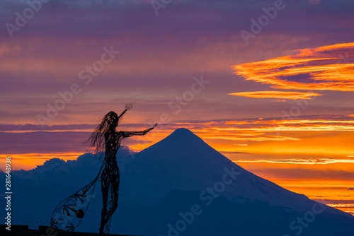 Zoom shot of beautiful sunrise colors on the shore of Lake Llanquihue with the unmistaken Osorno volcano in the background photo