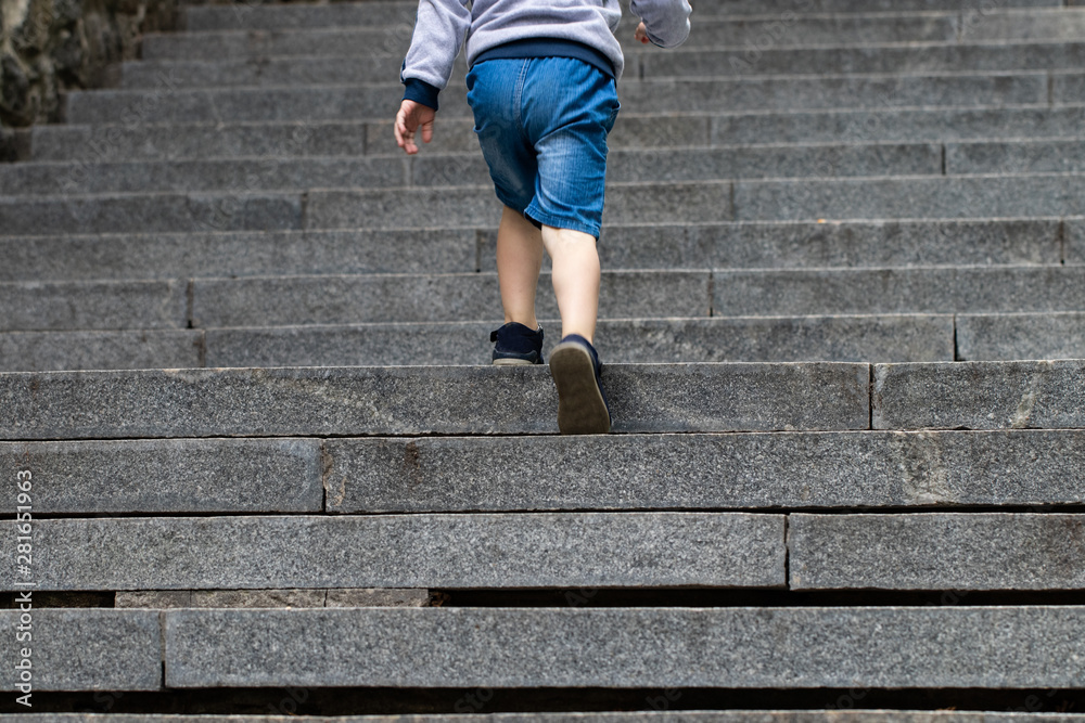 Boy climbing stairs stone - symbol of success