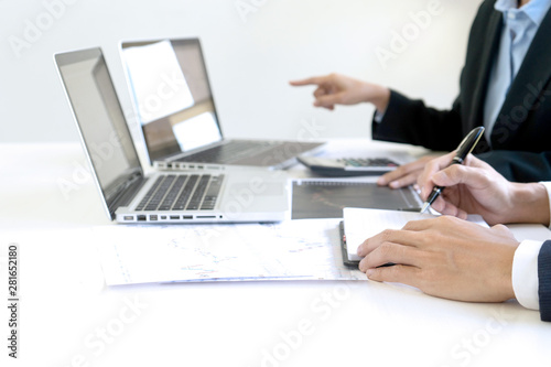 business man and woman sit at ther table looking at computer laptop