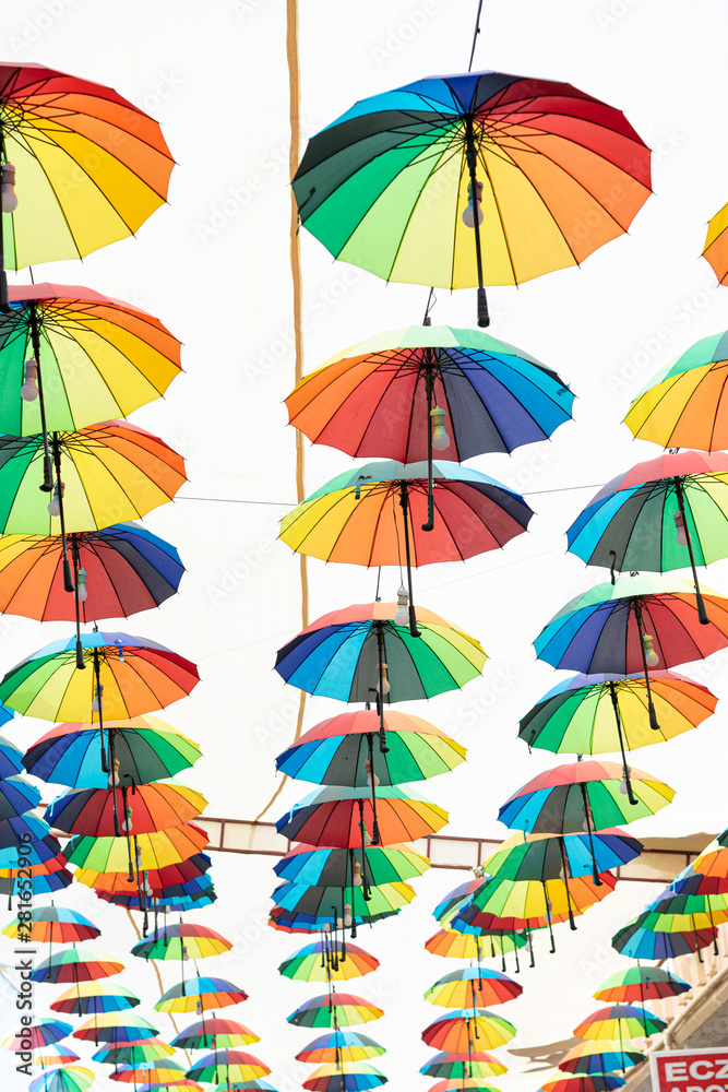 Multi-colored umbrellas hanging over the street