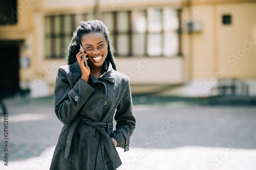 Portrait of pretty african woman in urban background talking on phone