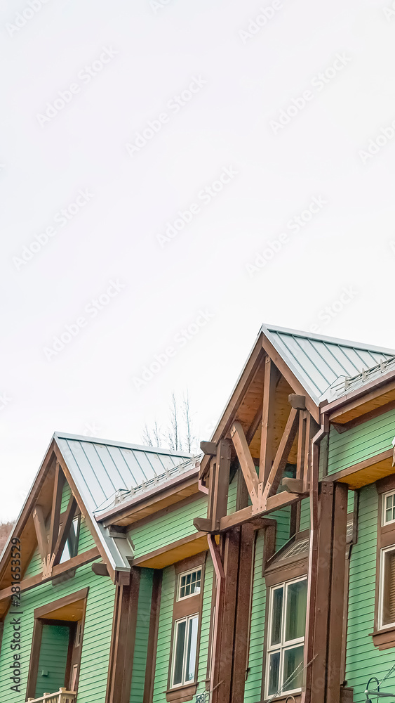 Vertical frame Exterior of the upper storey of homes with balconies and green horizontal siding