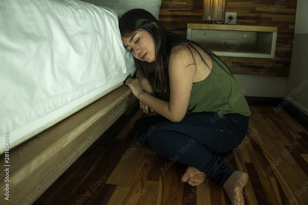 young depressed and sad Asian Korean woman sitting on floor at bedroom next to bed suffering depression problem and anxiety crisis feeling desperate young depressed and sad Asian Korean woman sitting on floor at bedroom next to bed suffering depression problem and anxiety crisis feeling desperate