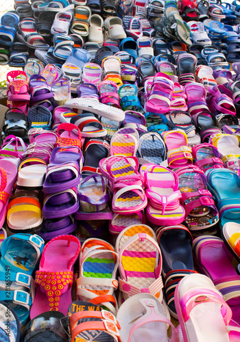 Summer multicolor footwear. Flip-flops and sandals on the market.