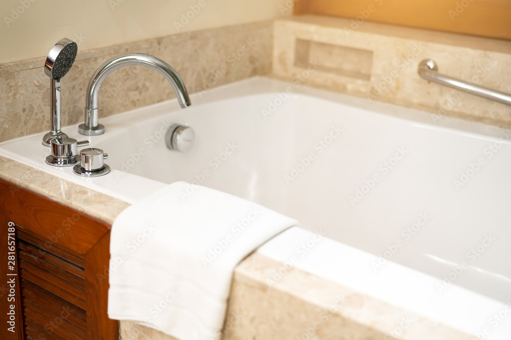 Asia hotel classic luxury bath with bath tub, faucet and white towel on white ceramic in a retro style.