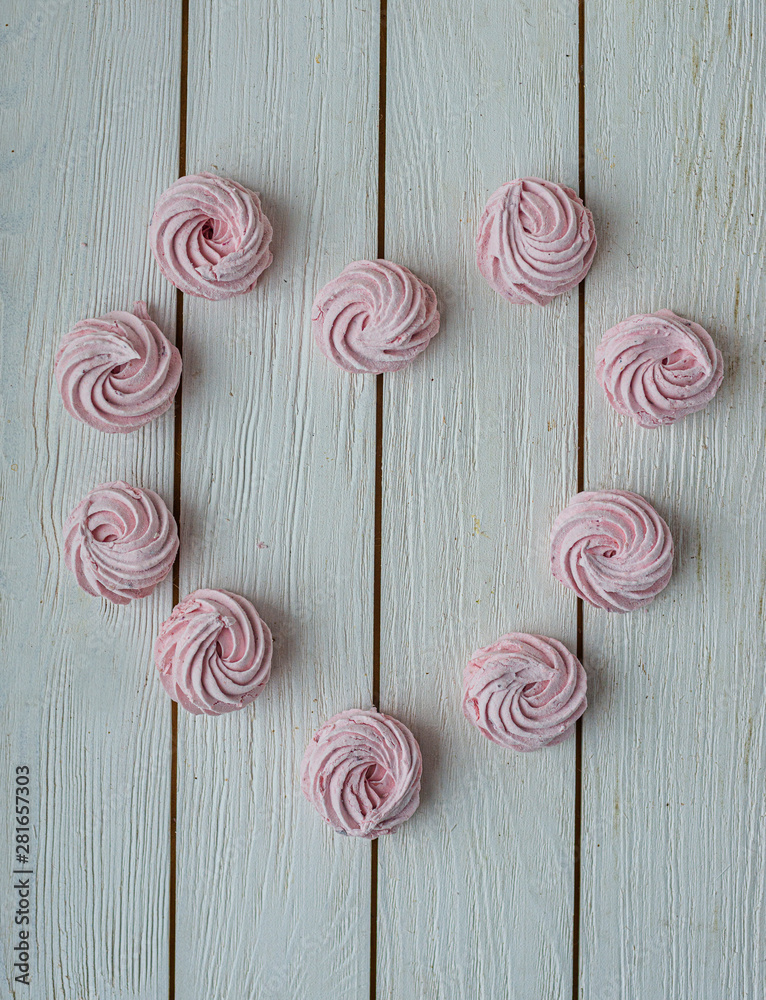 Zephyr lined in a heart shape on a white background. Flat lay. Top view. Pink sweet homemade zephyr or marshmallow. Colorful meringues on white. top view dessert image. Zephyr lined in a heart shape on a white background. Flat lay. Top view. Pink sweet homemade zephyr or marshmallow. Colorful meringues on white. top view dessert image.