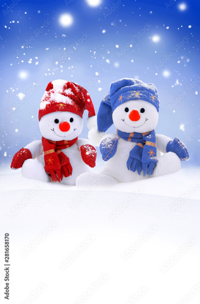 Two little snowmen the girl and the boy in caps and scarfs on snow in the winter. Background with a funny snowman. Christmas card.