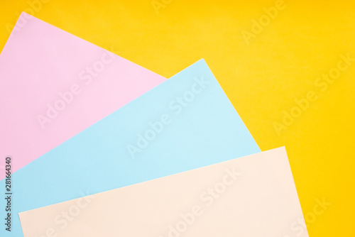 Colored paper on a yellow background. Geometric background.