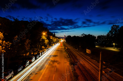 Nightscape road and rail track with car moving light trail long exposure photography in a city landscape during the night time