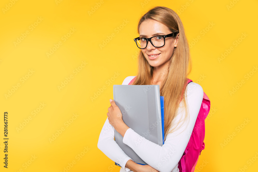 Study, education, university, college, graduate concept on yellow background. Portrait of beautiful smiling blonde woman. Young student with backpack Study, education, university, college, graduate concept on yellow background. Portrait of beautiful smiling blonde woman. Young student with backpack