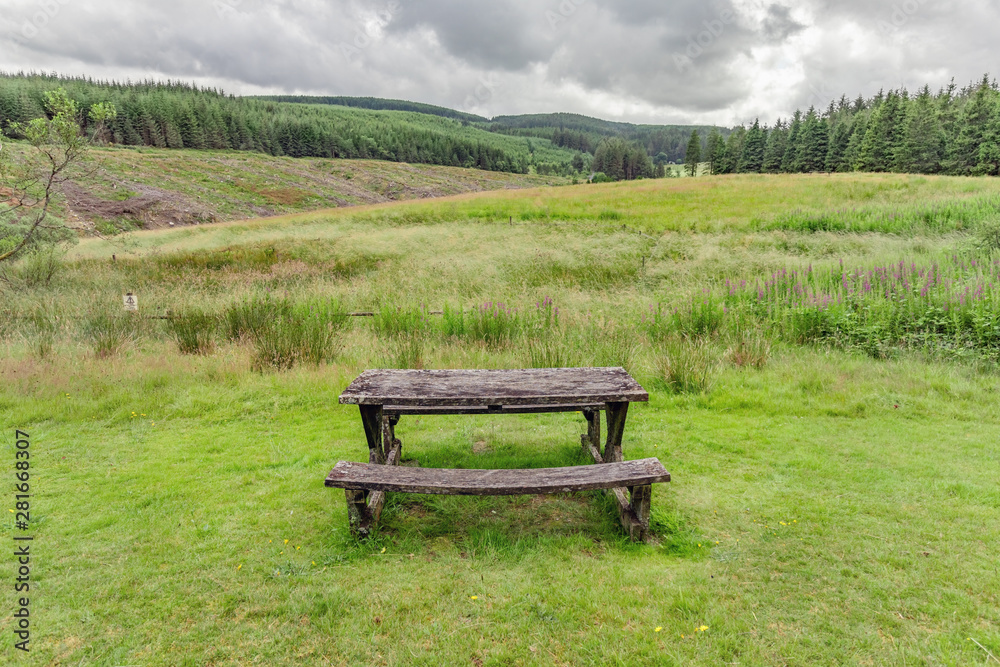 Isolated park bench in the countryside in mid-Wales, with a view of a stormy sky