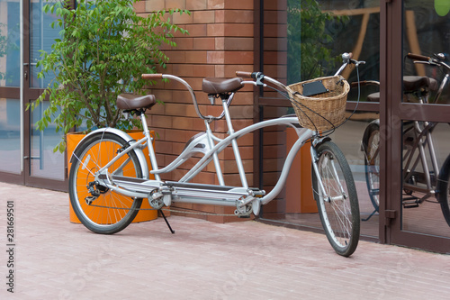 gray tandem bicycle in front of a street cafe on a summer day