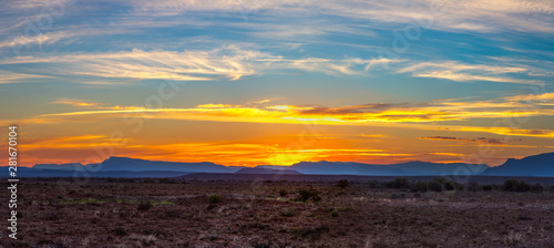 Sunset color the clouds yellow and the mountains blue