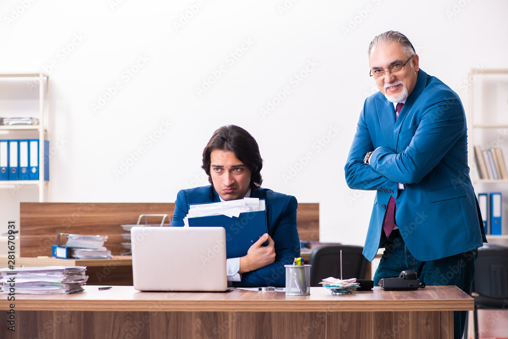 Young and old employees working together in the office Young and old employees working together in the office