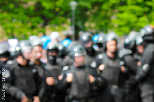 Blurred image of police at a mass event. A detachment of police in helmets protects the order at the rally. Policemen at a demonstration on a street