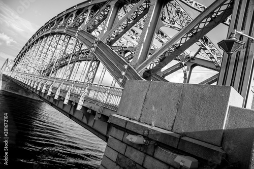black and white image of metal structures of the bridge. fragments of arches of bridge connections.