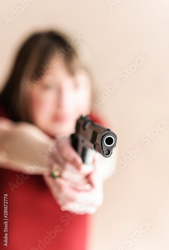 Woman with handgun carefully aims