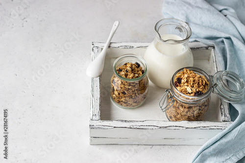 Granola in glass jars with raisins and milk. Healthy breakfast.