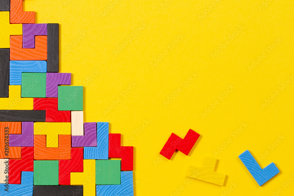 Different colorful shapes wooden blocks on yellow background. Top view