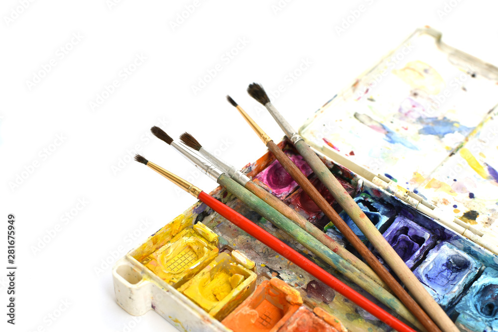 Obraz premium Art brushes and watercolor paints on isolated white background. Accessories and tools for creativity. Painting and drawing hobby. Back to school. Place for text. Copy space